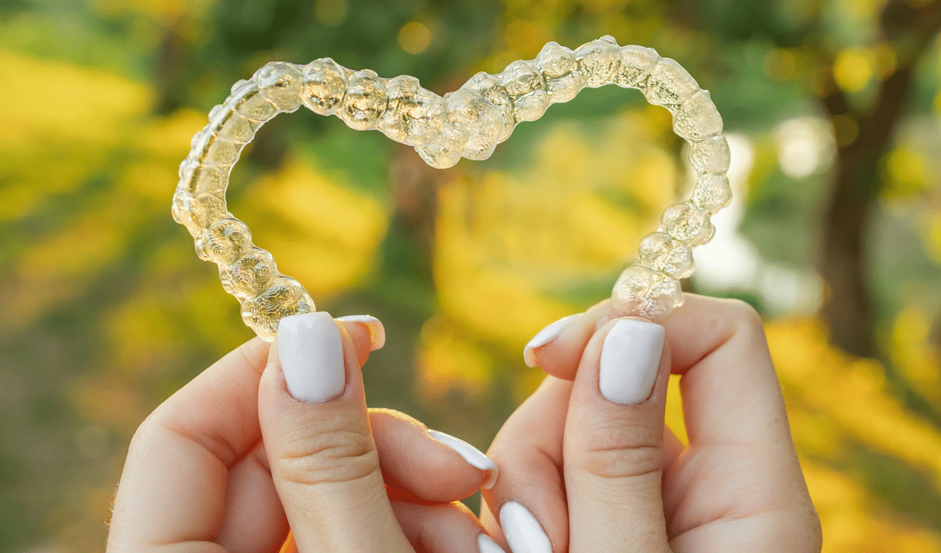 Hands forming heart with clear aligner Invisalign info | Advanced Orthodontics in Burien, WA